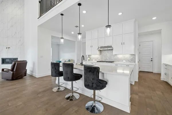 a kitchen with stainless steel appliances kitchen island granite countertop a table and chairs in it
