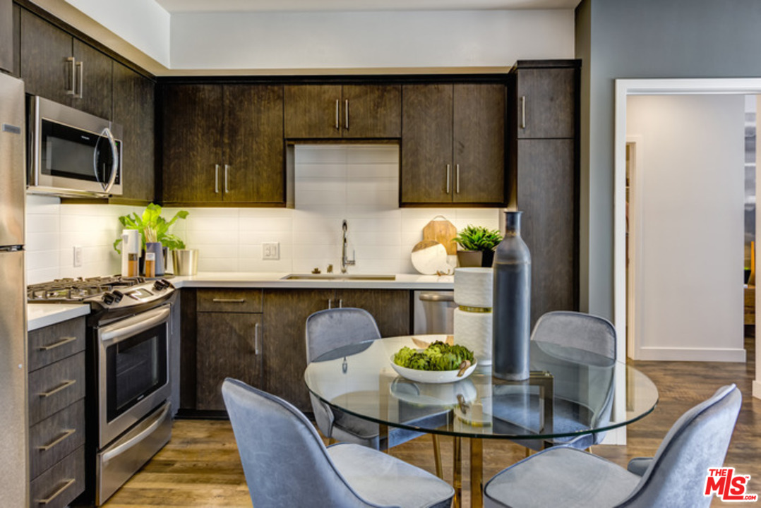 75 West Walnut Street, Unit 434 Pasadena, CA 91103 - Photo 2 of 22 a kitchen with stainless steel appliances kitchen island granite countertop a stove a sink a microwave and dining table