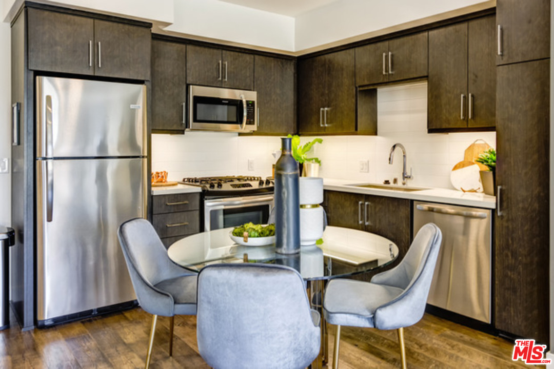 75 West Walnut Street, Unit 434 Pasadena, CA 91103 - Photo 3 of 22 a kitchen with a table chairs refrigerator and microwave