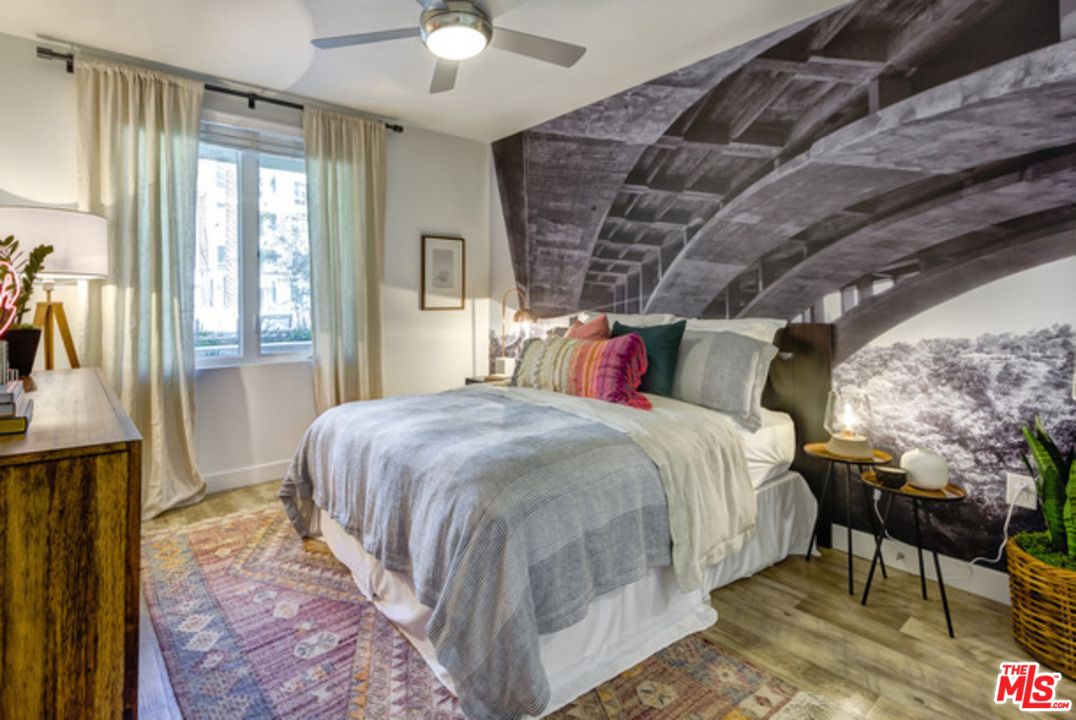 75 West Walnut Street, Unit 434 Pasadena, CA 91103 - Photo 4 of 22 a spacious bedroom with a bed and a chandelier