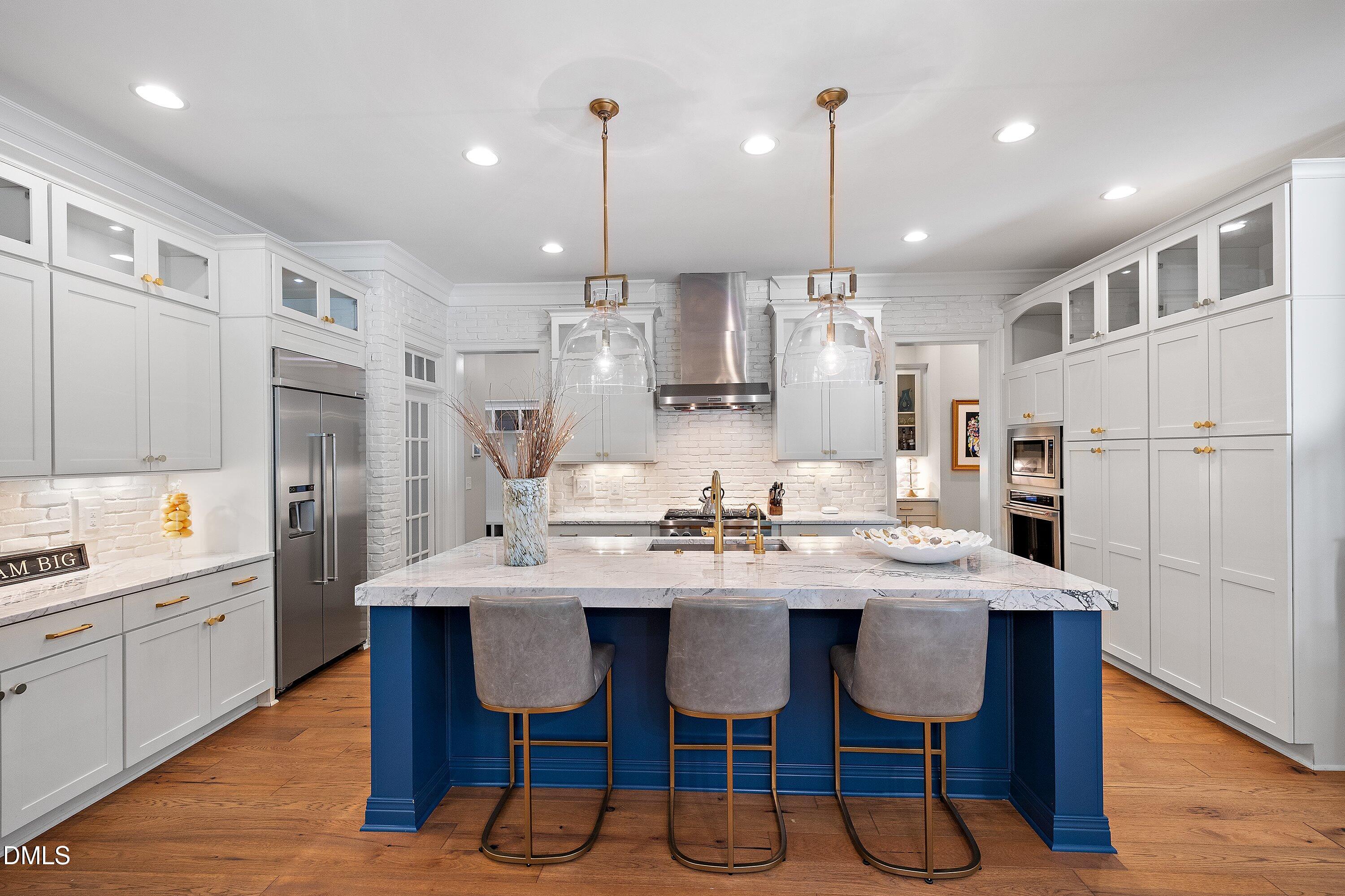 1536 Rock Dove Way Raleigh, NC 27614 - Photo 23 of 100 a kitchen with stainless steel appliances kitchen island granite countertop a dining table chairs and white cabinets