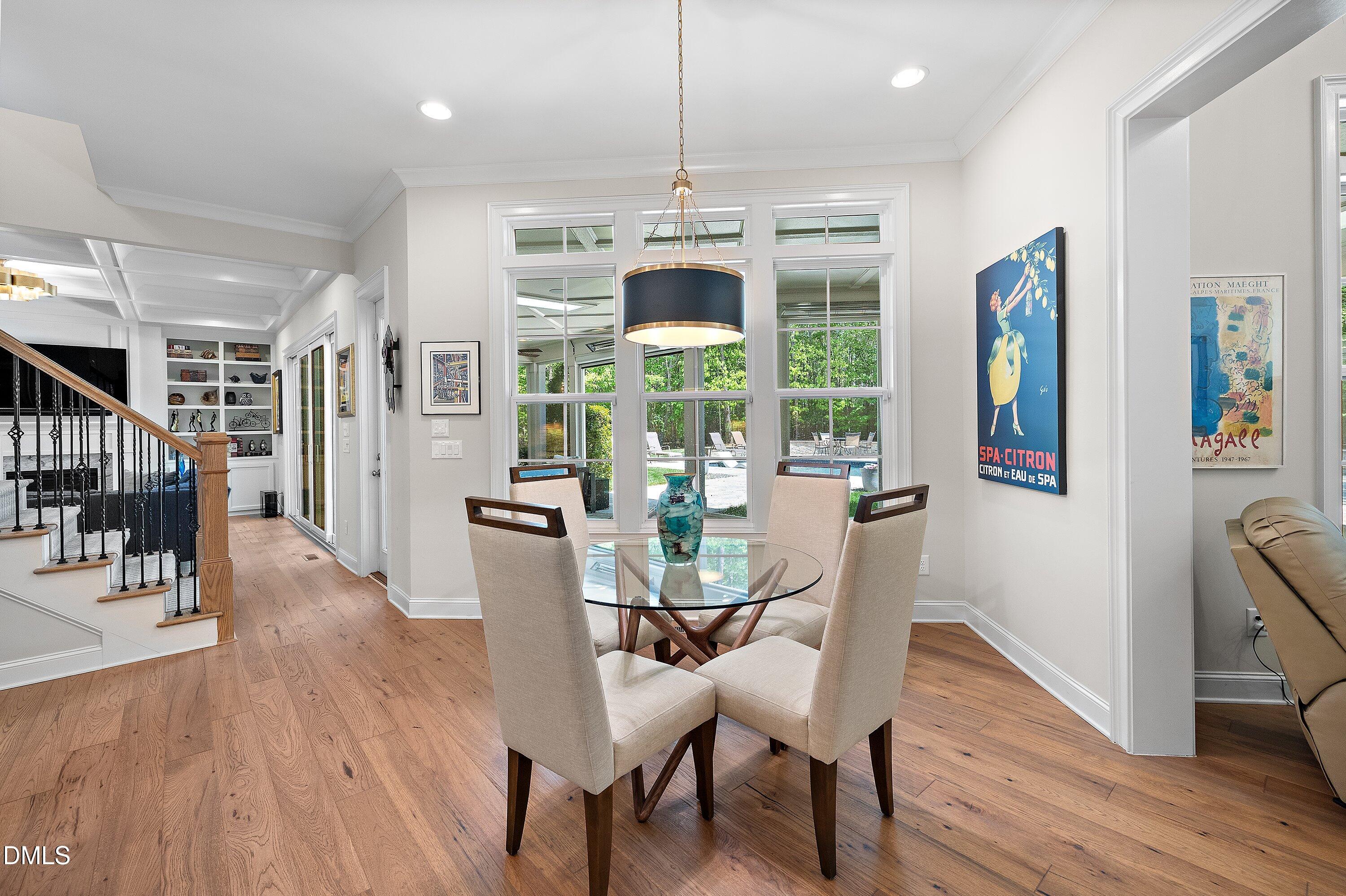 1536 Rock Dove Way Raleigh, NC 27614 - Photo 31 of 100 a dining room with wooden floor a chandelier a glass table and chairs