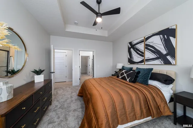 a bedroom with a large bed and a flat tv screen on dresser