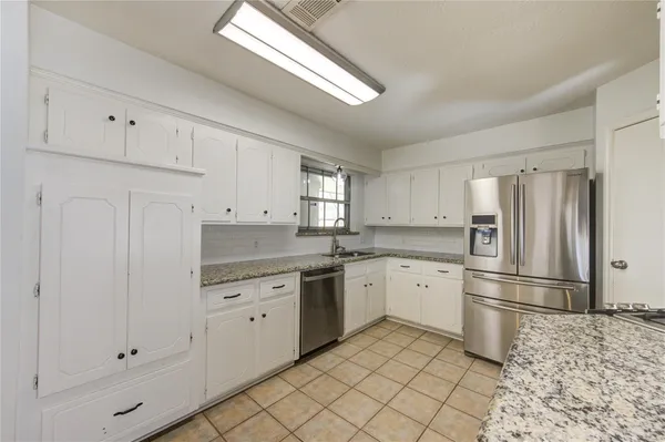 a kitchen with stainless steel appliances granite countertop a stove a sink and a refrigerator