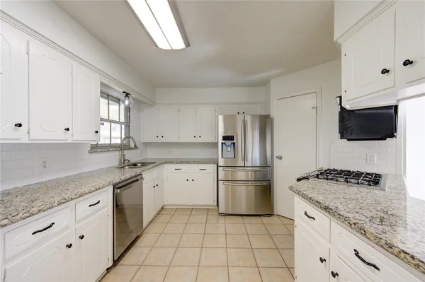 a kitchen with stainless steel appliances granite countertop a refrigerator and a stove
