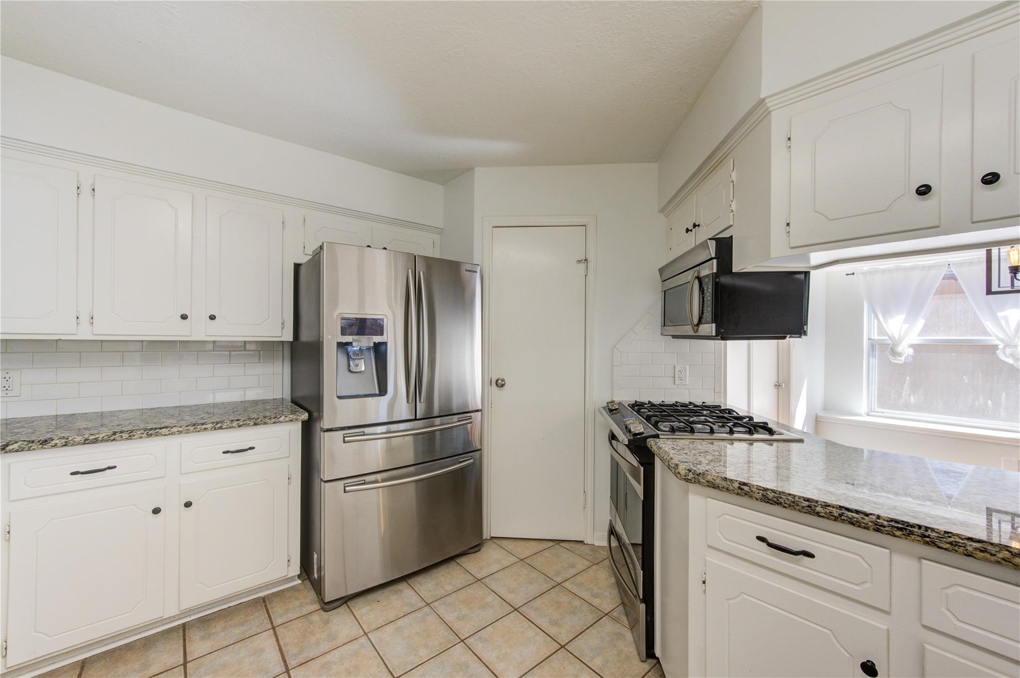 29115 Raestone Street Spring, TX 77386 - Photo 18 of 40 a kitchen with stainless steel appliances granite countertop a refrigerator and a stove