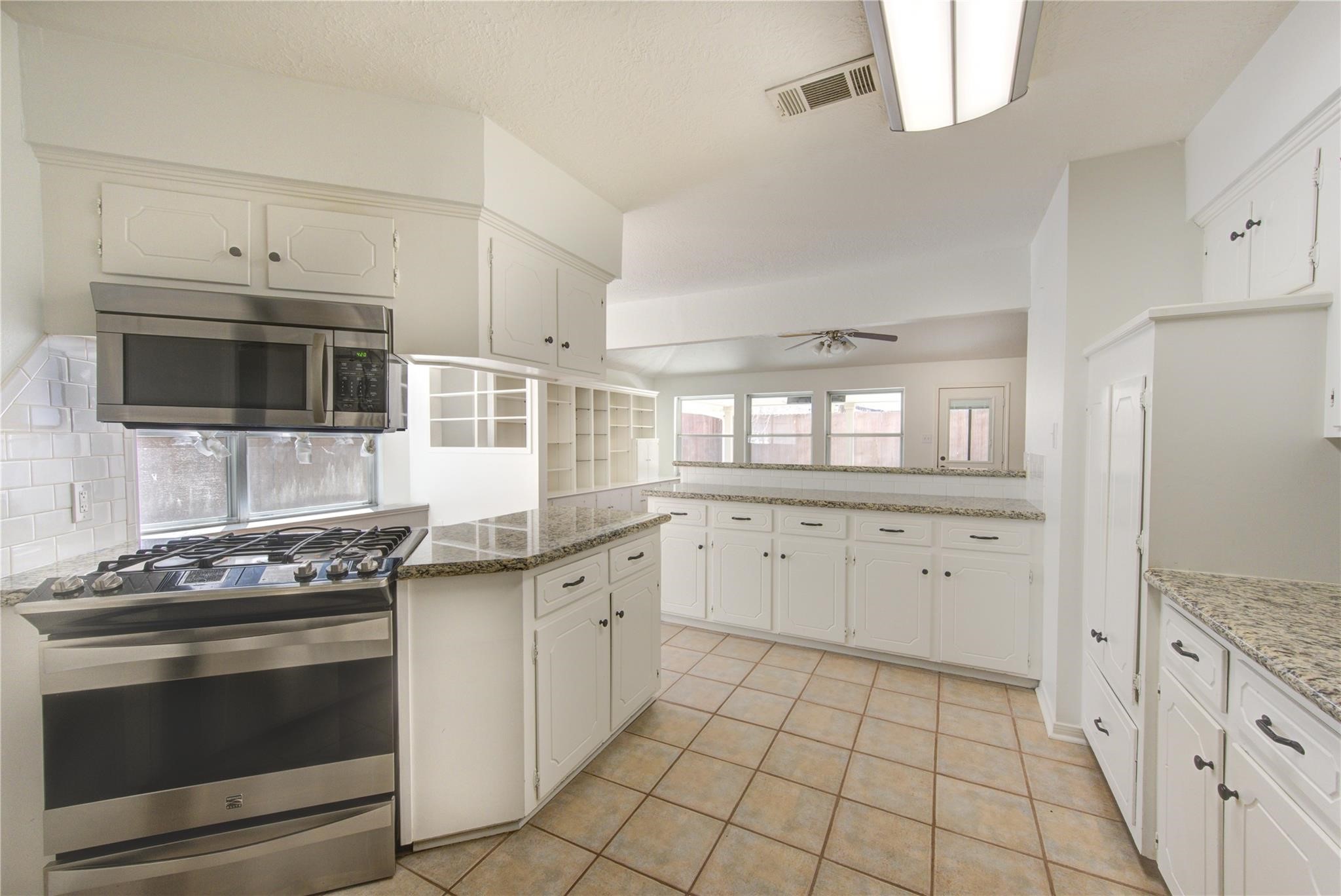 29115 Raestone Street Spring, TX 77386 - Photo 19 of 40 a kitchen with granite countertop a stove sink and cabinets