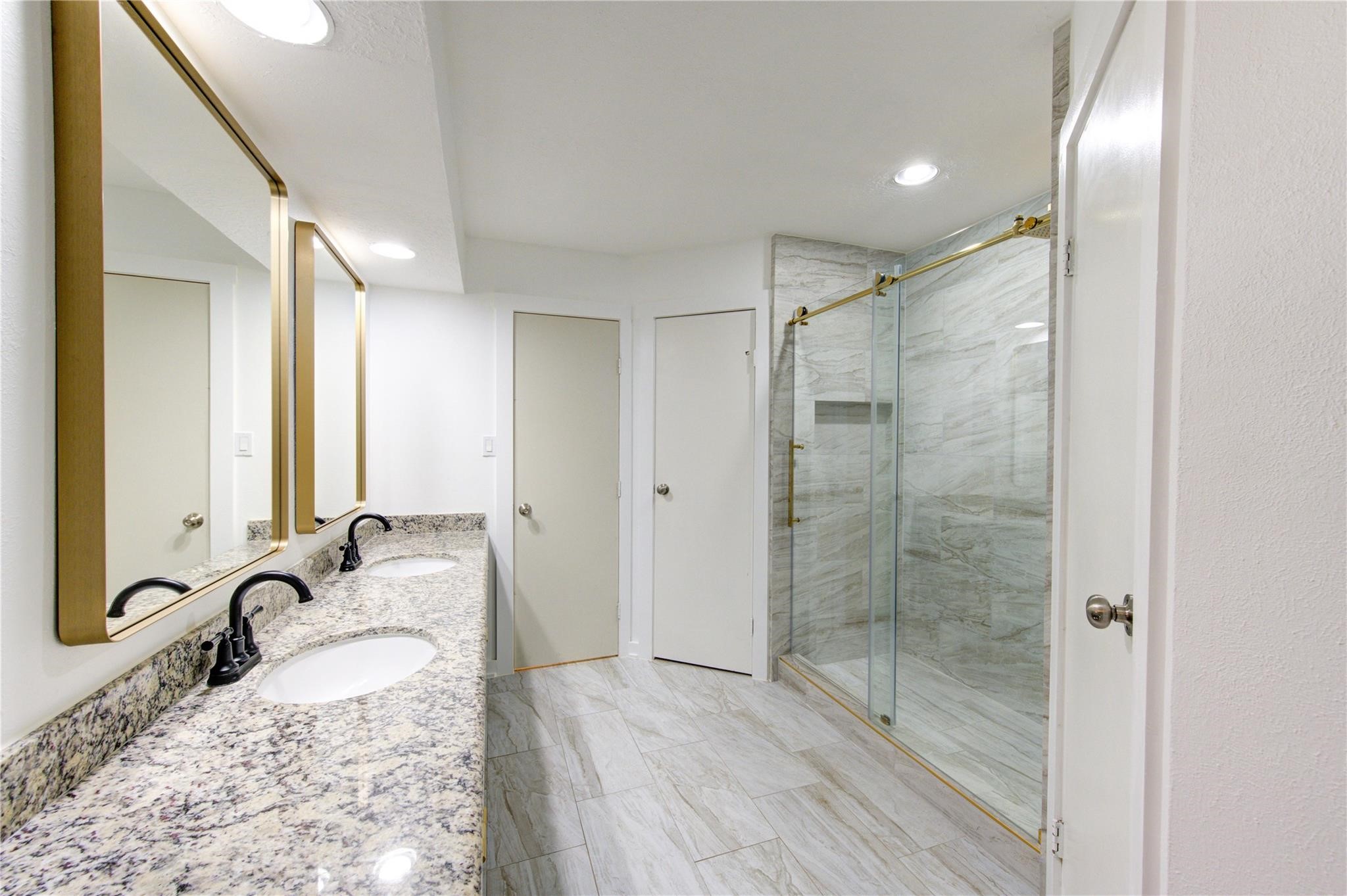 29115 Raestone Street Spring, TX 77386 - Photo 23 of 40 a bathroom with a granite countertop sink a mirror and shower