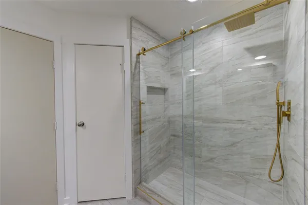 a bathroom with a granite countertop double vanity and a mirror