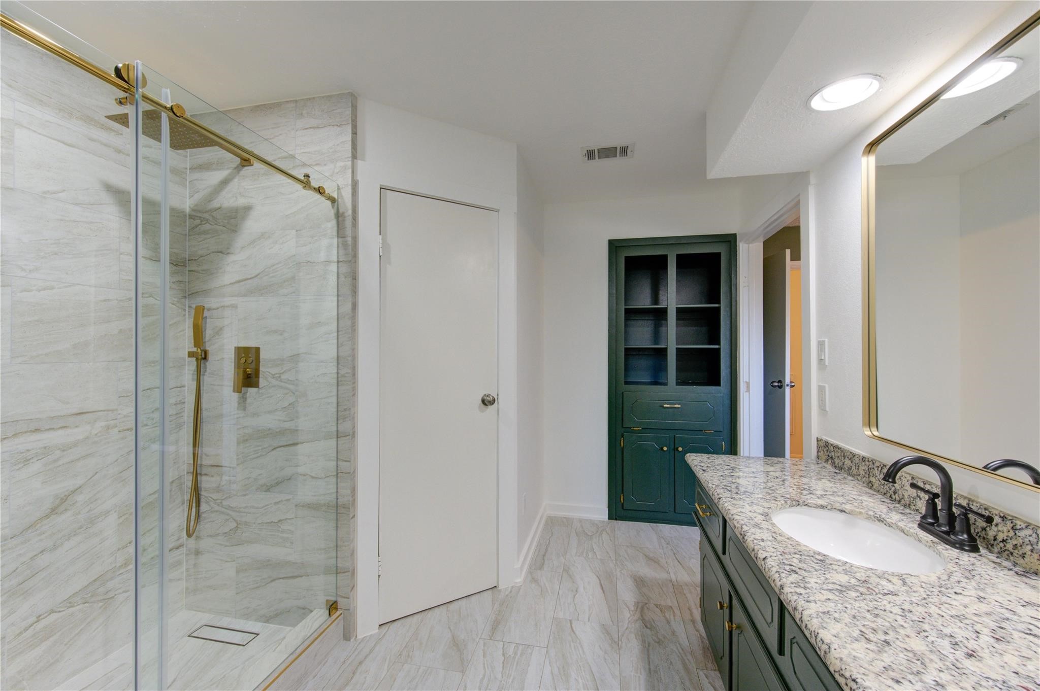 29115 Raestone Street Spring, TX 77386 - Photo 26 of 40 a bathroom with a granite countertop sink a mirror and shower
