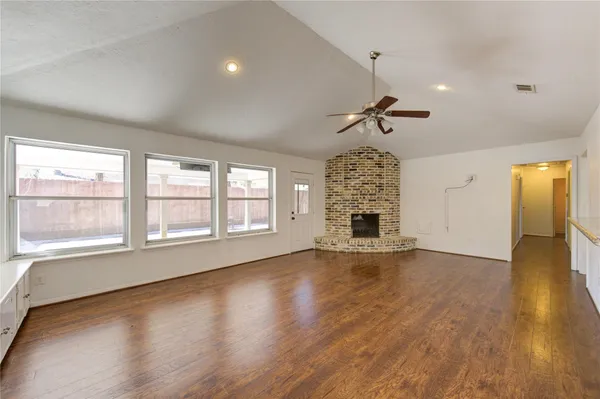a view of empty room with wooden floor and fireplace