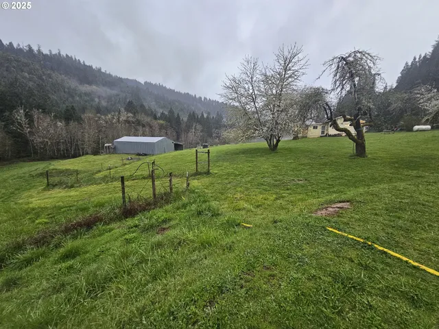 a view of a green field with wooden fence