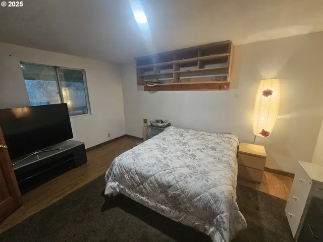 a bedroom with a bed and wooden floor