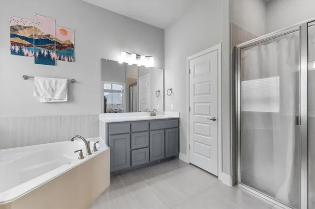 a spacious bathroom with a tub sink and mirror