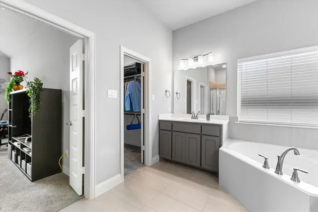 a bathroom with a tub sink and mirror
