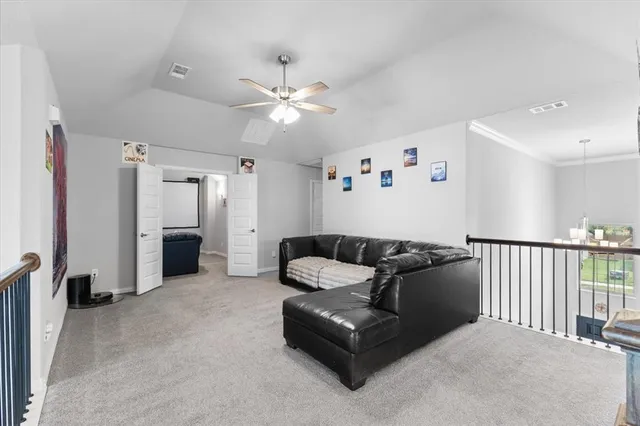 a living room with furniture and a ceiling fan