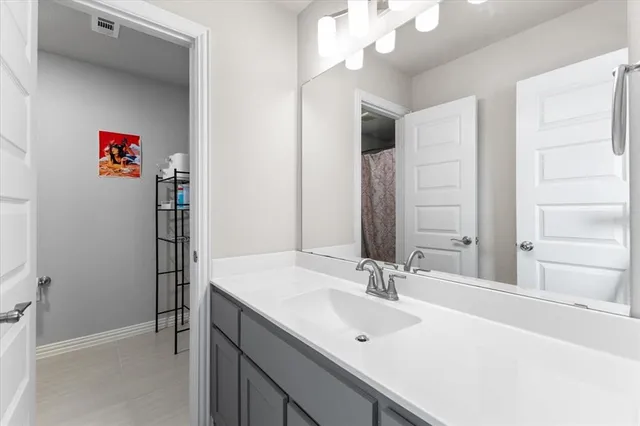 a bathroom with a sink vanity and a mirror