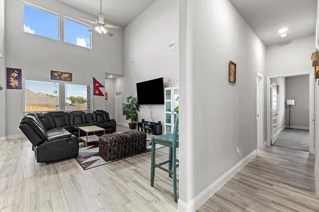 a living room with furniture a flat screen tv and a wooden floor