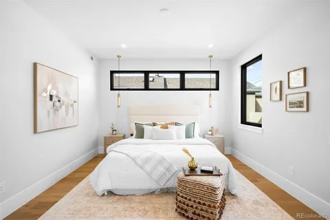 a bedroom with a bed and painting on the wall