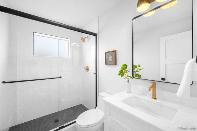 a bathroom with a granite countertop sink mirror toilet and shower