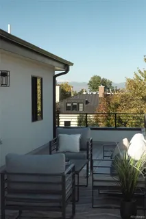 a roof deck view with table and chairs and potted plants