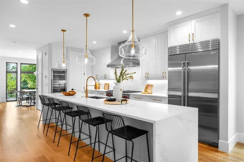 a kitchen with stainless steel appliances a dining table chairs and couches