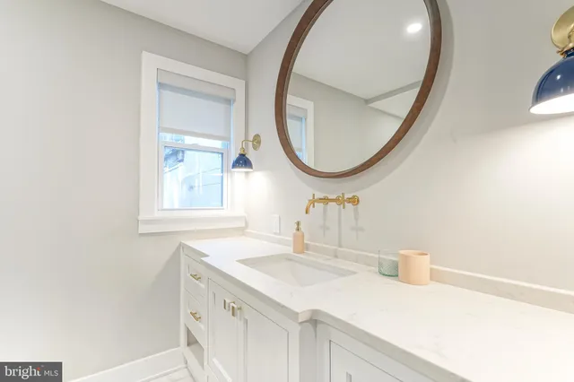 a bathroom with a sink a mirror and vanity