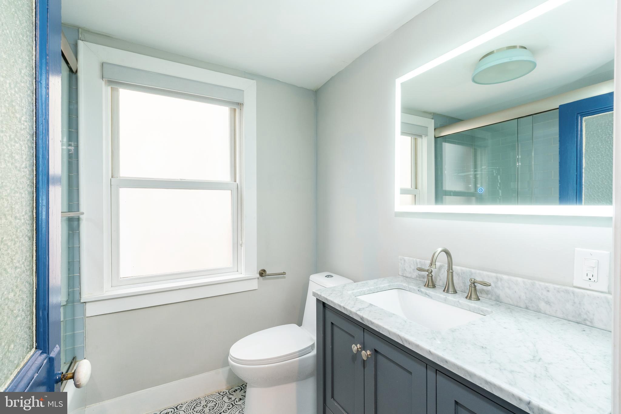 2314 South Street Philadelphia, PA 19146 - Photo 58 of 83 a bathroom with a granite countertop sink toilet and mirror