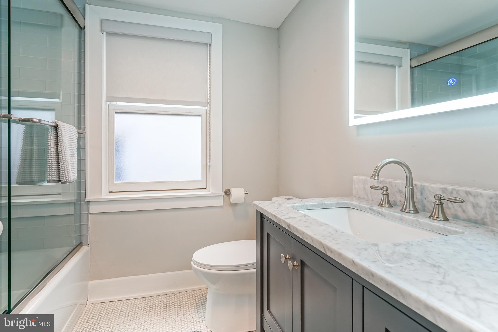 2314 South Street Philadelphia, PA 19146 - Photo 62 of 83 a bathroom with a granite countertop sink toilet and mirror