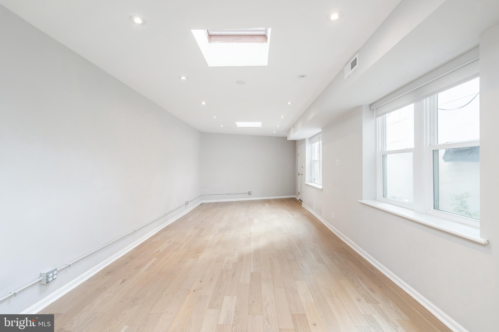 2314 South Street Philadelphia, PA 19146 - Photo 66 of 83 an empty room with wooden floor and windows
