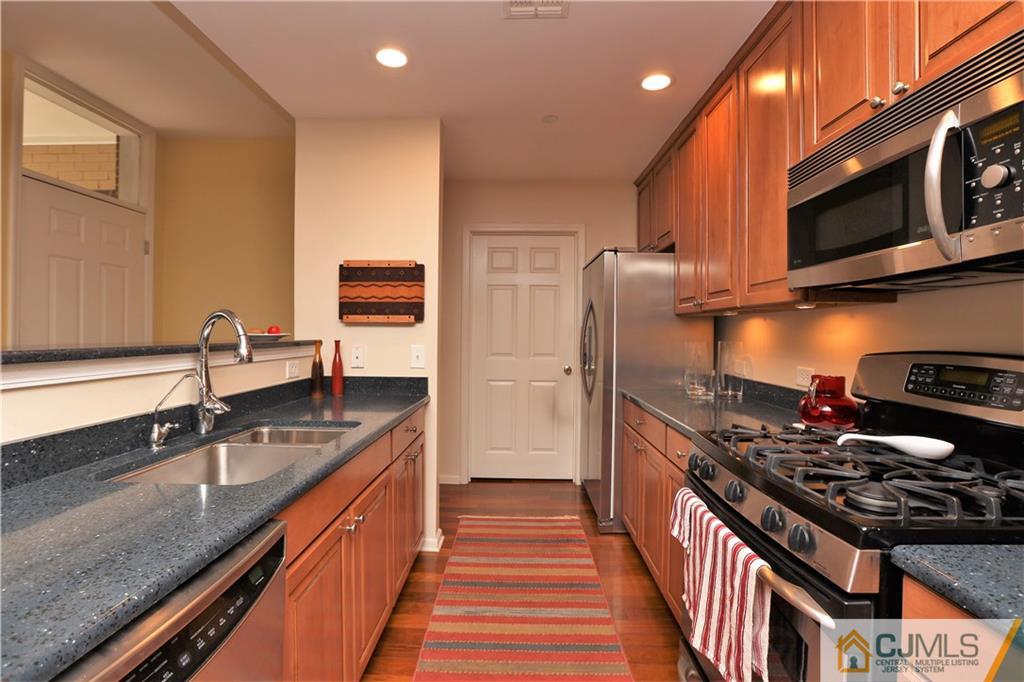 358 Rector Street, Unit 219 Perth Amboy, NJ 08861 - Photo 6 of 17 a kitchen with stainless steel appliances granite countertop a stove a sink and a refrigerator