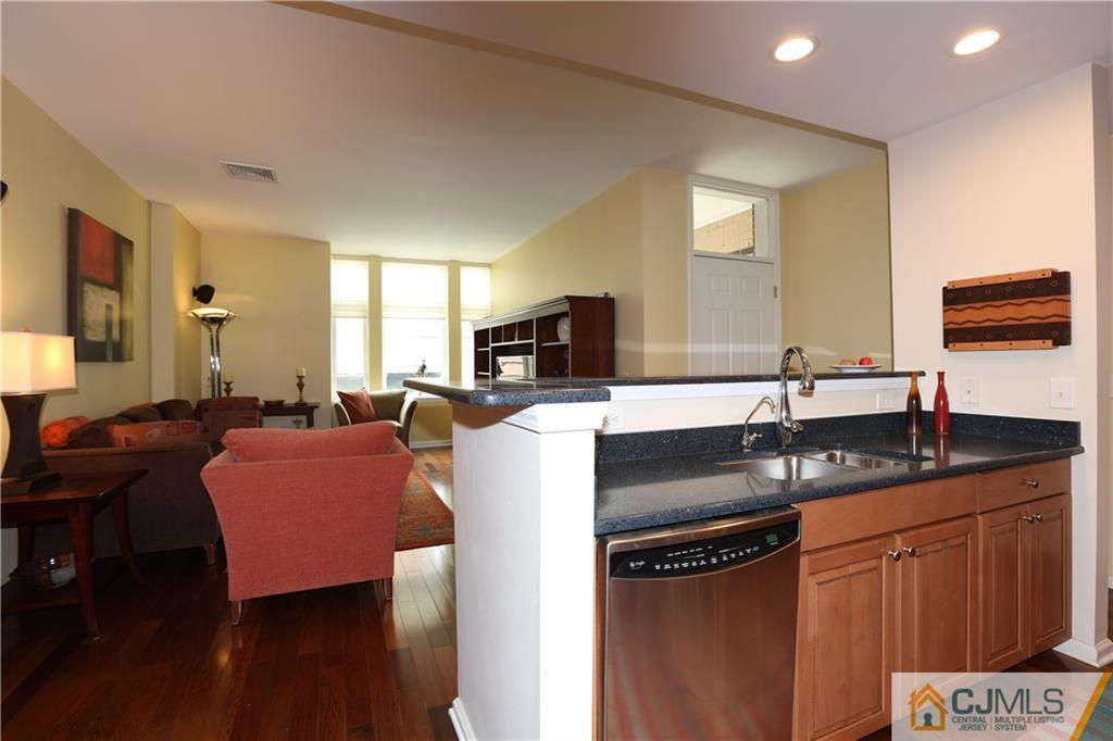 358 Rector Street, Unit 219 Perth Amboy, NJ 08861 - Photo 7 of 17 a kitchen with granite countertop a sink and a refrigerator