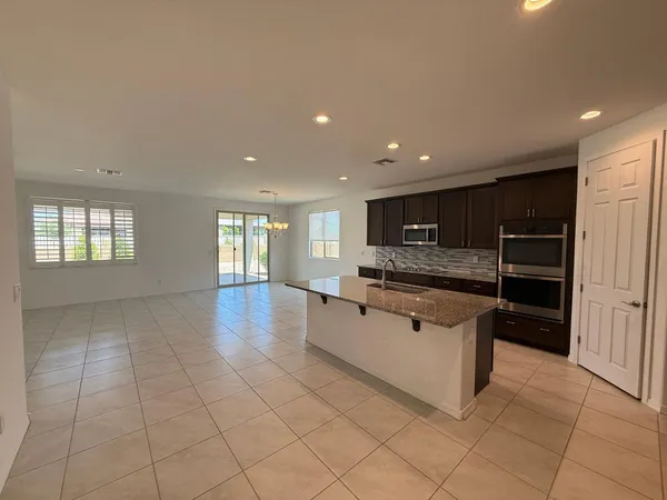 a large kitchen with stainless steel appliances granite countertop a large counter top and a stove top oven