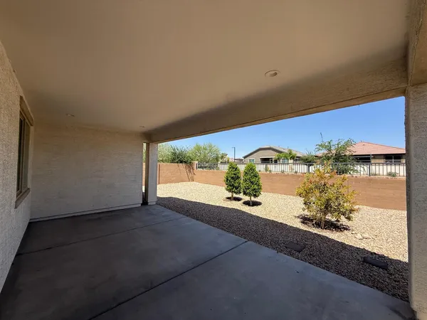 a view of a house with a floor to ceiling window and potted plants