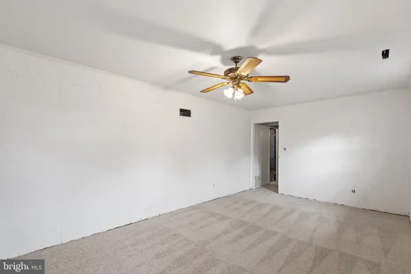 a view of a big room with wooden floor and chandelier fan