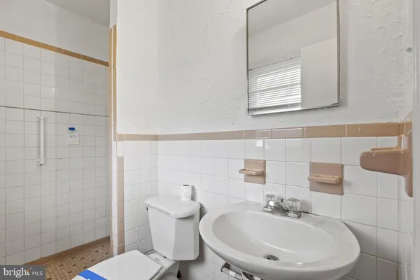 a bathroom with a sink a toilet and a mirror