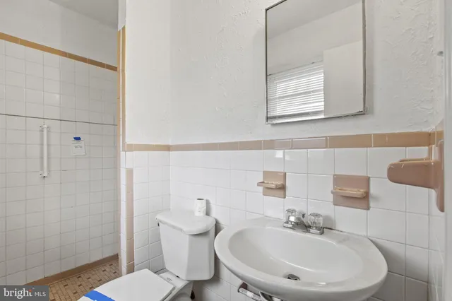 a bathroom with a sink a toilet and a mirror