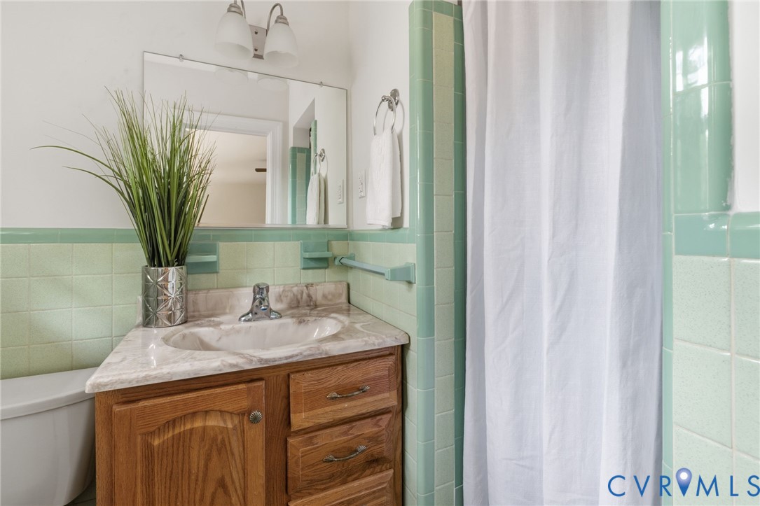 3140 Archdale Road Richmond, VA 23235 - Photo 24 of 48 a bathroom with a granite countertop sink a mirror and a shower curtain