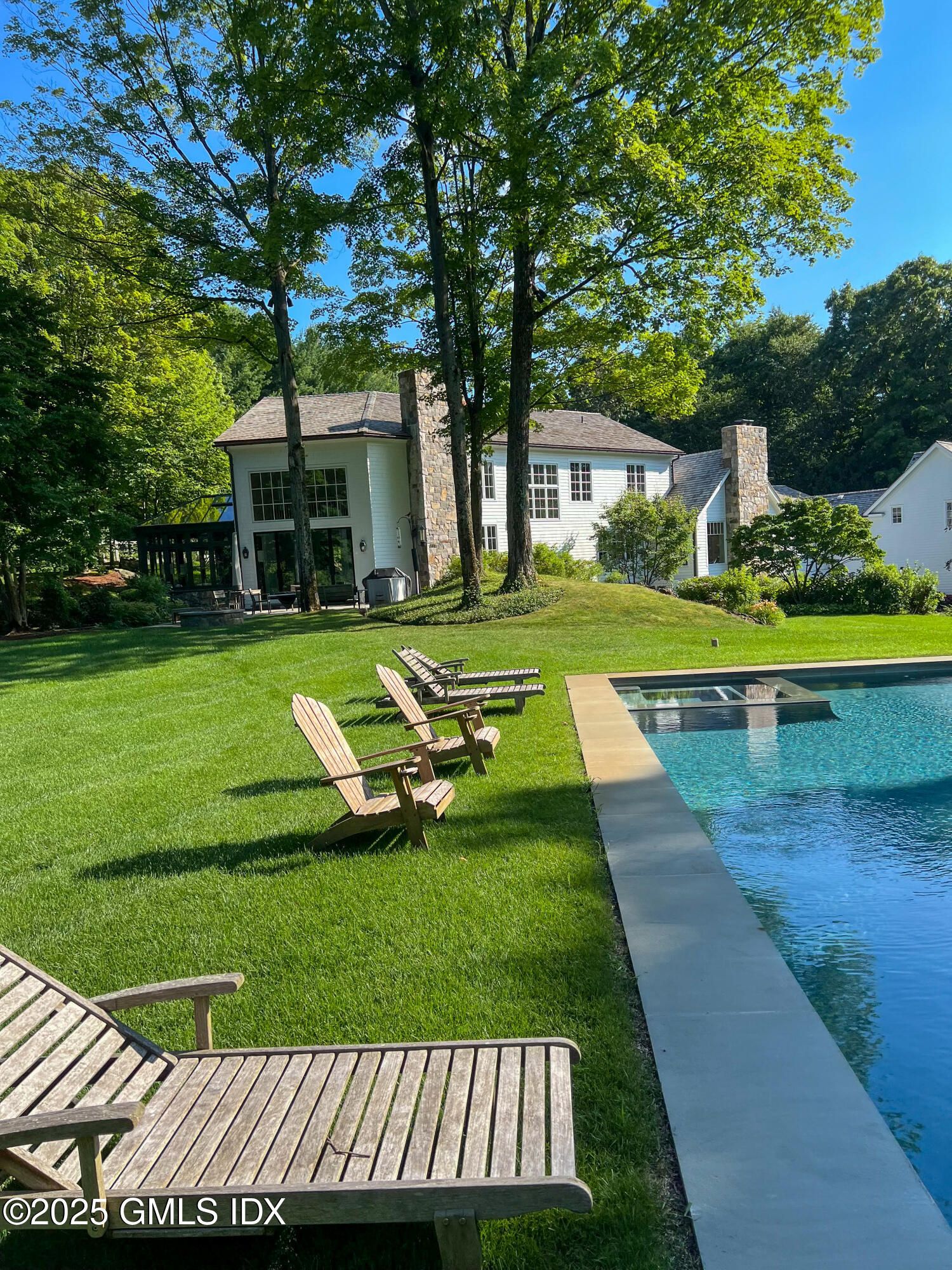 70 Sumner Road Greenwich, CT 06831 - Photo 4 of 57 a view of a swimming pool and lounge chairs in back yard