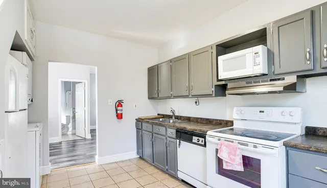 a kitchen with stainless steel appliances granite countertop a stove a sink and a white cabinets