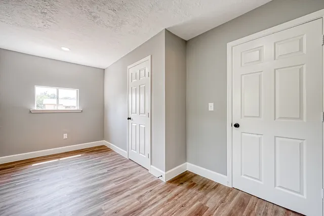 a view of an empty room with wooden floor