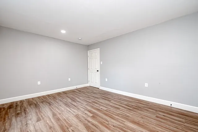 a view of an empty room with wooden floor