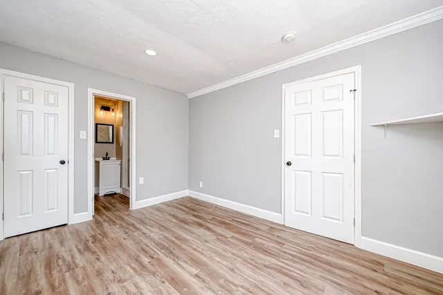 a view of an empty room with wooden floor