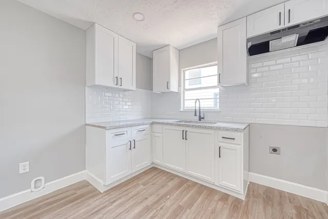 a kitchen with granite countertop white cabinets and white appliances