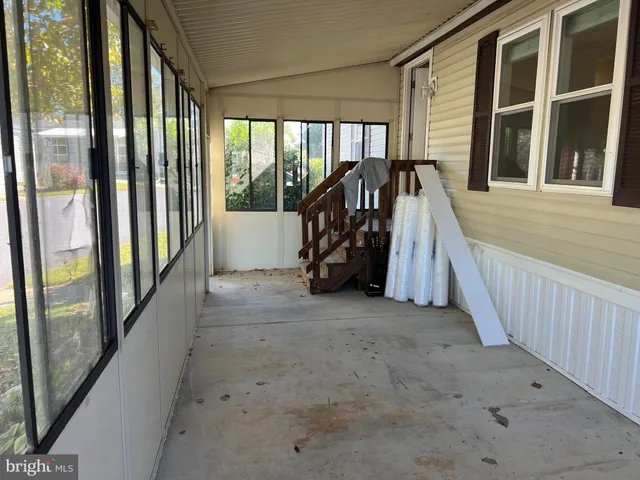 a view of a porch with wooden floor and windows