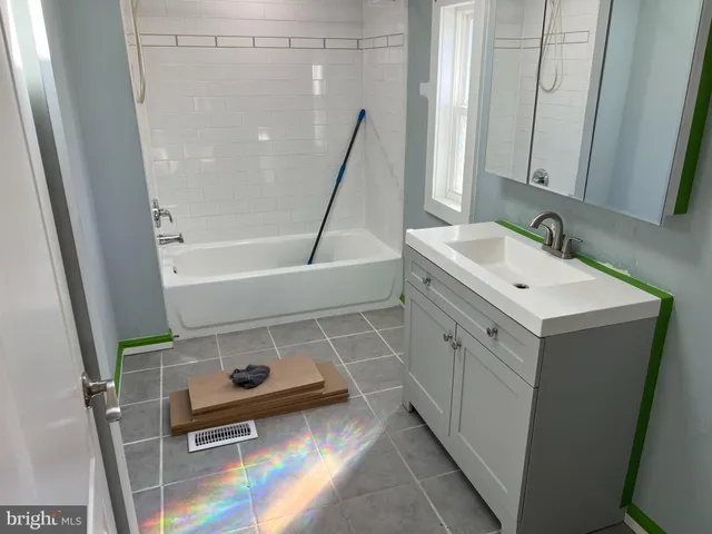 a bathroom with a sink a toilet a mirror and shower