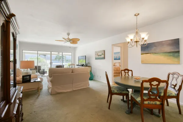 a living room with furniture a chandelier and a dining table