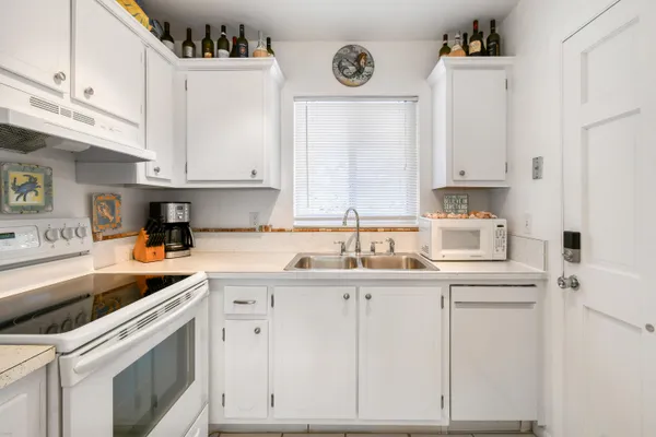 a kitchen with cabinets appliances a sink and a stove