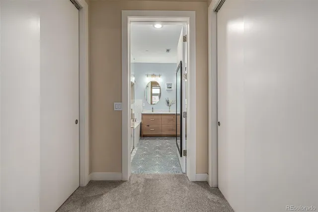 a view of a hallway with a livingroom and a bathroom