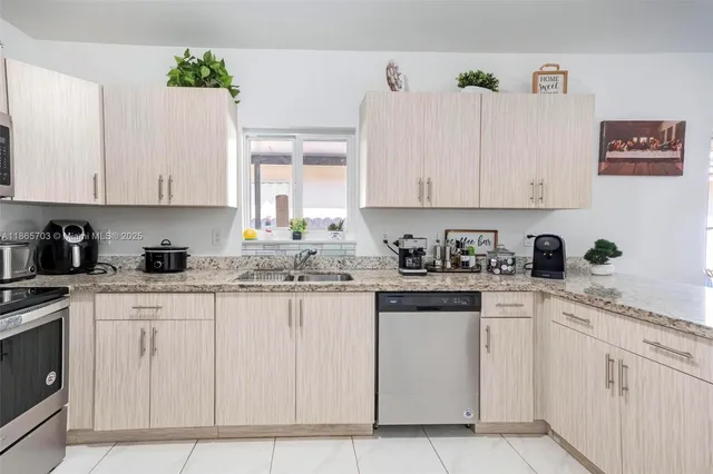 a kitchen with white cabinets white appliances and sink